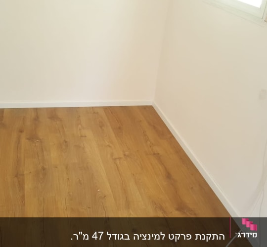 רצפת פרקט עץ בחדר עם קירות לבנים